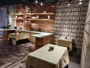 a restaurant with tables and a brick wall at 蓮園旅舘-桃園店 in Taoyuan