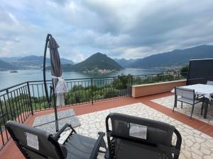 une terrasse avec un parasol, une table et des chaises dans l'établissement Appartamento vista Lago d'Iseo, à Sulzano
