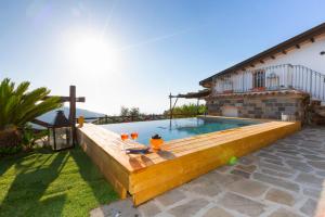 - une piscine avec une terrasse en bois à côté d'une maison dans l'établissement I Giardini di Sorrento, à Sorrente