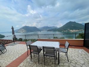- une table et des chaises sur une terrasse avec vue sur l'eau dans l'établissement Appartamento vista Lago d'Iseo, à Sulzano 2 autres photos