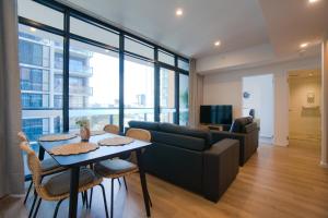 ein Wohnzimmer mit einem Sofa und einem Tisch in der Unterkunft Contemporary 3BR Paradise on Franklin Street in Adelaide
