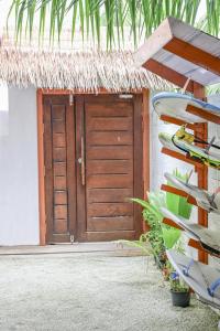 a door to a house with a thatch roof at Thulusdhoo Inn in Thulusdhoo