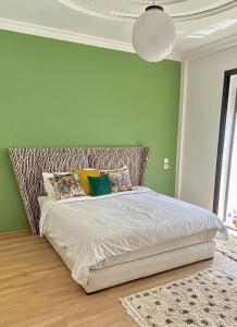 1 cama en un dormitorio con una pared verde en Villa avec piscine privée sur agadir en Agadir