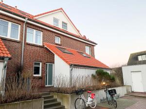 twee fietsen geparkeerd voor een bakstenen huis bij Düünleev in Langeoog