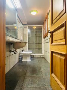 uma casa de banho com um WC, um lavatório e uma porta em Magnolia ItalianHostings Wine em Bolonha