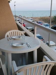 una mesa blanca y sillas en un balcón con vistas a la playa en Apartamentos Argonavis, en L'Estartit