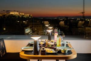 a table with plates of food on a balcony at Academias Hotel, Autograph Collection in Athens