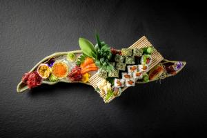 a plate of food with sushi on a table at Academias Hotel, Autograph Collection in Athens
