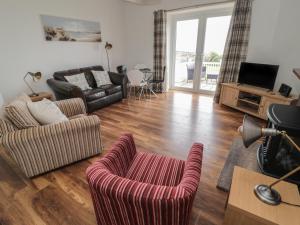 sala de estar con sofá y silla en South Cottage Howick, en Craster