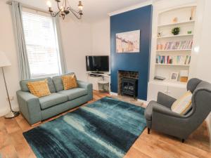 ein Wohnzimmer mit einem Sofa, 2 Stühlen und einem TV in der Unterkunft 22 St Marys Walk in Scarborough