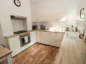 Eine Küche mit weißen Schränken und Holzboden in der Unterkunft 22 St Marys Walk in Scarborough + 8 Fotos