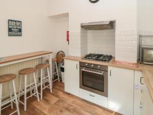 eine Küche mit weißen Schränken und einem Herd in der Unterkunft 22 St Marys Walk in Scarborough