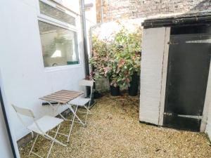 eine Terrasse mit 2 Stühlen, einem Tisch und einem Fenster in der Unterkunft 22 St Marys Walk in Scarborough