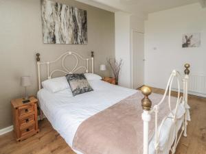 a bedroom with a white bed and a wooden floor at Seaview Howick in Craster