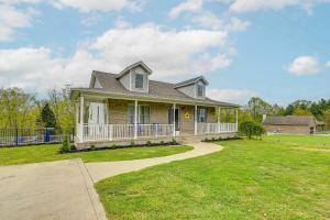 a house with a porch and a grass yard at Home with Private Pool - 15 miles to Ark Encounter! in Berry