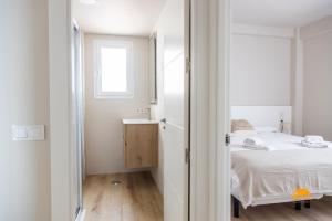 a small bedroom with a bed and a window at Malibu by Cadiz Time in Cádiz