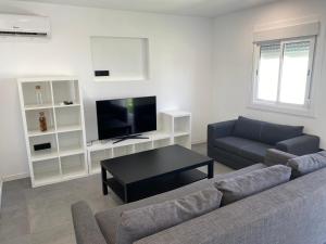 uma sala de estar com um sofá e uma televisão em dreamhouse_chiclna2 em Chiclana de la Frontera