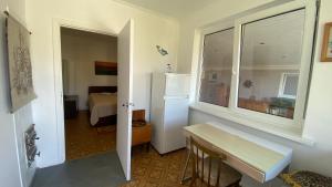 Habitación con nevera y dormitorio con cama. en Alyvų Vila - Palanga All House Just For You en Palanga