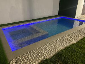 uma piscina com luzes azuis na relva em dreamhouse_chiclna2 em Chiclana de la Frontera