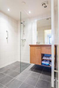 een badkamer met een douche, een wastafel en een spiegel bij Royale bungalow met grote tuin en terras in Munstergeleen