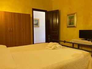 a bedroom with two beds and a flat screen tv at Araxi in Villa San Pietro