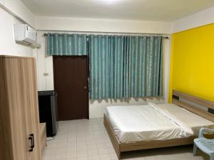 a bedroom with a bed and a window and a door at Hotel lima lima in Pattaya