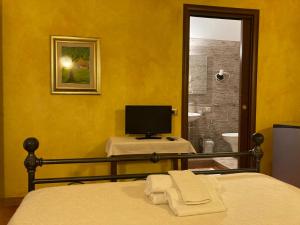 a bedroom with a bed and a tv and a bathroom at Araxi in Villa San Pietro