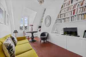 a living room with a yellow couch and a tv at Benjamine in Paris