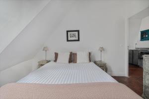 a bedroom with a large white bed with pillows at Benjamine in Paris