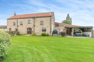 a large brick house with a large yard at Stubbs Grange Barn in Fenwick