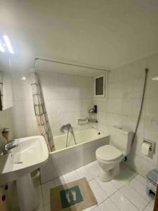 een badkamer met een toilet, een bad en een wastafel bij Lovely flat Korydallos in Piraeus