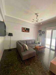 ein Wohnzimmer mit einem Sofa und einem Tisch in der Unterkunft Lovely flat Korydallos in Piräus
