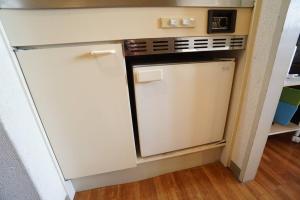 een kleine keuken met een fornuis en een koelkast bij Apartment House Floor Assemble 402 in Osaka