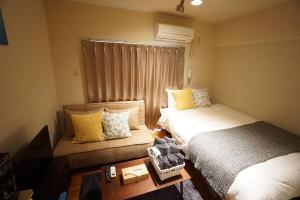 een kleine kamer met 2 bedden en een raam bij Apartment House Floor Assemble 402 in Osaka