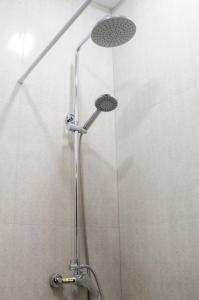 a shower with a shower head in a bathroom at Kenut Hostel in Yerevan