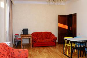 a living room with a red couch and a table at Kenut Hostel in Yerevan