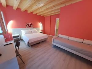 - une chambre avec des murs rouges, un lit et un canapé dans l'établissement Ca Jole, à Burano