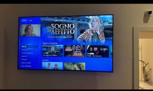 TV de pantalla plana colgada en la pared en Caracciolo Napoli BeB, en Nápoles