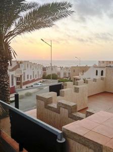 widok na miasto z budynkami i palmą w obiekcie Sunset Villa by the Ocean w mieście Ibekhchach