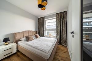 um quarto com uma cama e uma janela em ResiNest Apartamenty Jurowiecka J11 em Bialystok