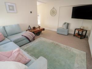 a living room with a couch and a flat screen tv at The Moorings in Deganwy
