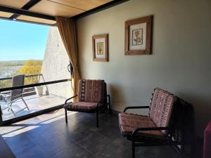 Zimmer mit 2 Stühlen und Balkon in der Unterkunft APART CLUB San Pedro Río Naturaleza y Relax in San Pedro