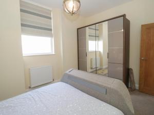 a bedroom with a bed and a large mirror at The Moorings in Deganwy