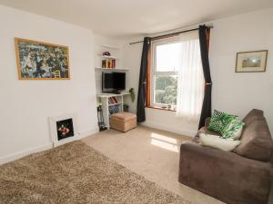 a living room with a couch and a window at Seaview Central in Southsea
