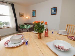 a dining room table with plates and a vase of flowers at Seaview Central in Southsea