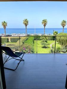 una silla en el balcón con vistas al océano en Appartamento "La casa du Capu", en Capo dʼOrlando