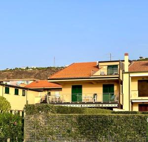 Casa amarilla con balcón con valla en Appartamento "La casa du Capu", en Capo dʼOrlando