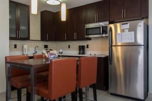a kitchen with a table and a stainless steel refrigerator at Residence Inn Raleigh-Durham Airport/Brier Creek in Raleigh
