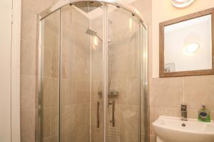 een douche met een glazen deur in een badkamer bij 8 Rosewall Cottages in St Ives +21 foto's