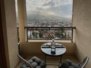 d'une table et de chaises sur un balcon avec vue. dans l'établissement Stylish Apartment, Skopje Centre - Private Parking - Panoramic views, à Skopje